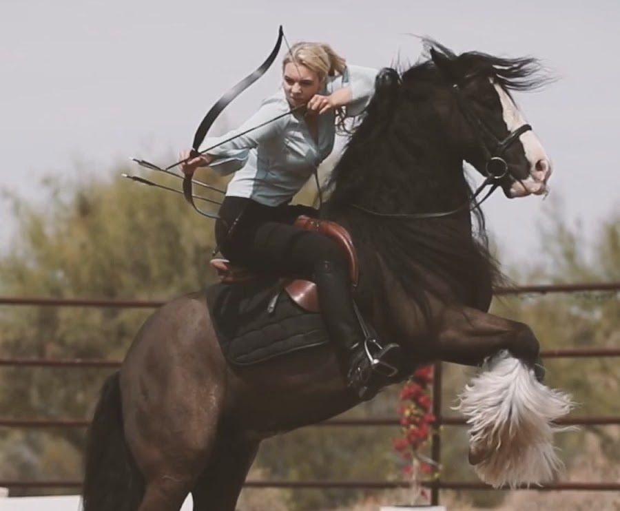 Horsegirl Alex Bauwens performing mounted archery on a gypsy vanner horse